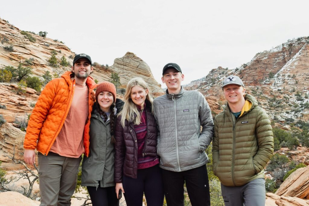 Five friends enjoying a scenic hike in Zion National Park with stunning rocky backgrounds.